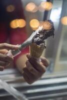 Close up hand of a person scooping ice cream in to a cone with blurred background photo
