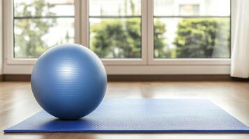 Blue yoga mat with pilates ball in modern fitness studio, closeup. photo