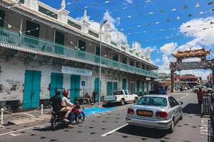 Port Louis, Mauritius - January 14, 2023 - A diverse group of individuals standing in front of a building, located in Port Louis City, Mauritius, with a prominent mosque in the background. photo