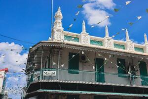 Port Louis, Mauritius - January 14, 2023 - A diverse group of individuals standing in front of a building, located in Port Louis City, Mauritius, with a prominent mosque in the background. photo
