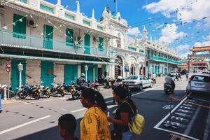 Port Louis, Mauritius - January 14, 2023 - A diverse group of individuals standing in front of a building, located in Port Louis City, Mauritius, with a prominent mosque in the background. photo