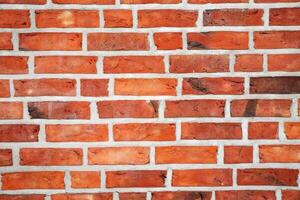 Red brick wall texture background with weathered bricks, cement joints, and an aged, grungy appearance photo
