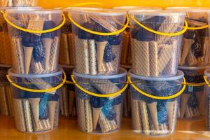 stack of containers with waffle cones and chocolate sauce photo