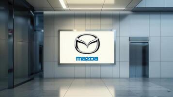 illuminated sign with the logo of mazda an automotive company inside the lobby of a modern building. photo