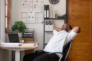 Exhausted American Businessman Taking a Break from Long Hours of Work in a Modern Home Office Setting photo