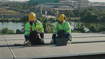 Men technicians carrying photovoltaic solar modules on the factory roof. Engineers in helmets installing solar panel systems outdoors. Concept of alternative and renewable energy solar cell. video