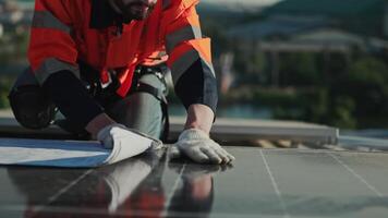 Men technicians carrying photovoltaic solar modules on the factory roof. Engineers in helmets installing solar panel systems outdoors. Concept of alternative and renewable energy solar cell. video