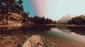 A lake surrounded by trees and rocks under a cloudy sky video