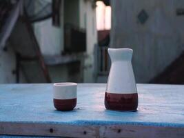 Two ceramic vases sit on a table in front of a building video