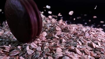 Chocolate chip cookies falling into oatmeal in slow motion on dark background video