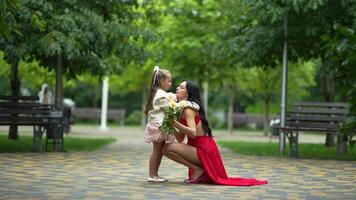 Mother and daughter share a heartwarming moment in a tranquil park setting on a sunny day video