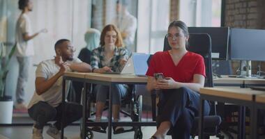 A diverse group of colleagues collaborates using laptops, mobiles, and tablets to tackle business challenges and enhance productivity through teamwork and innovative technology. video