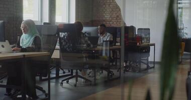 A diverse group of business colleagues engage in discussions about various business challenges, surrounded by their coworkers in a modern startup office, showcasing teamwork, innovation, and problem video