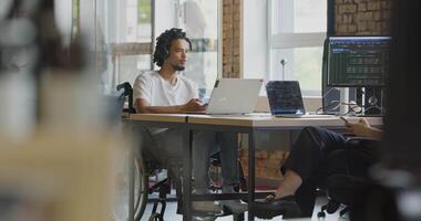 A diverse group of colleagues collaborates using laptops, mobiles, and tablets to tackle business challenges and enhance productivity through teamwork and innovative technology. video