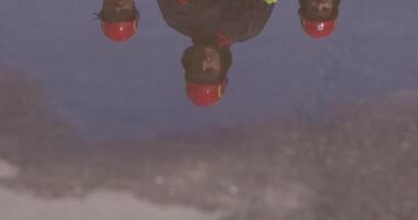 The reflection in water reveals a team of specially equipped firefighters coordinating and embarking on a high-risk, life-saving mission to rescue people in distress, showcasing their unwavering video