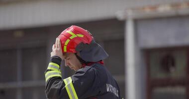 A firefighter removes their helmet after a dangerous rescue mission, symbolizing the end of a heroic effort to save victims from a fire, showcasing their dedication and sacrifice in the face of danger video