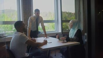 A diverse group of business colleagues engage in discussions about various business challenges, surrounded by their coworkers in a modern startup office, showcasing teamwork, innovation, and problem video