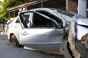 A close-up view of the condition of a silver-colored sedan destroyed in an accident. photo