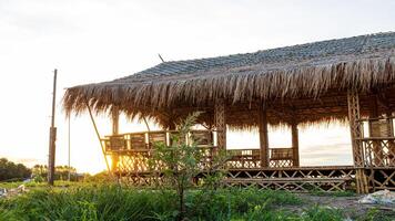 Low angle view of a bamboo frame shack with a thatched roof. photo