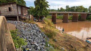 Side view of large granite boulders piled up on a riverbank mound. photo