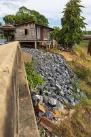 Side view of large granite boulders piled up on a riverbank mound. photo