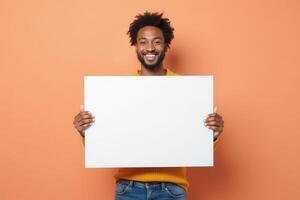 Smiling Man Holding Blank White Sign Against Orange Background photo