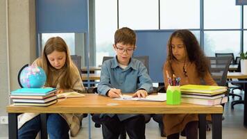 Group of diverse pupils studying in classroom video