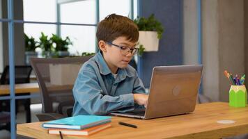 Thoughtful boy using laptop in computer class at school video