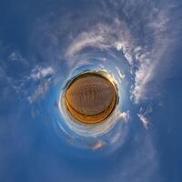 simple little tiny planet without buildings in blue sky with beautiful clouds. Transformation of spherical panorama 360 degrees. Spherical abstract aerial view. Curvature of space. photo