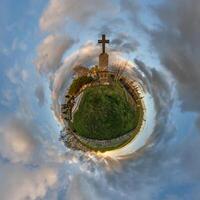 pequeño minúsculo planeta con tumba cruzar en cementerio en azul cielo con hermosa nubes transformación de esférico panorama 360 grados esférico resumen aéreo vista. curvatura de espacio. foto