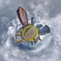 abstract swirling tiny planet spherical panorama of multi-storey buildings of skyscrapers of a residential complex in the form of a butterfly, bugs, crabs in blue sky photo