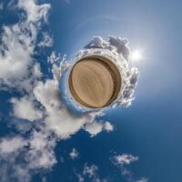 simple little tiny planet without buildings in blue sky with beautiful clouds. Transformation of spherical panorama 360 degrees. Spherical abstract aerial view. Curvature of space. photo