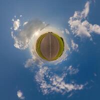 simple little tiny planet without buildings in blue sky with beautiful clouds. Transformation of spherical panorama 360 degrees. Spherical abstract aerial view. Curvature of space. photo
