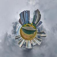 abstract swirling tiny planet spherical panorama of multi-storey buildings of skyscrapers of a residential complex in the form of a butterfly, bugs, crabs in blue sky photo