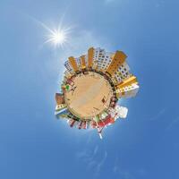 abstract swirling tiny planet spherical panorama of multi-storey buildings of skyscrapers of a residential complex in the form of a butterfly, bugs, crabs in blue sky photo