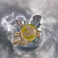 abstract swirling tiny planet spherical panorama of multi-storey buildings of skyscrapers of a residential complex in the form of a butterfly, bugs, crabs in blue sky photo