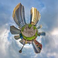 abstract swirling tiny planet spherical panorama of multi-storey buildings of skyscrapers of a residential complex in the form of a butterfly, bugs, crabs in blue sky photo