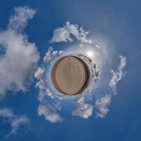 simple little tiny planet without buildings in blue sky with beautiful clouds. Transformation of spherical panorama 360 degrees. Spherical abstract aerial view. Curvature of space. photo