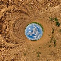 blue hole sphere or globe little planet inside sand or dry ground frame background with tractor tracks photo