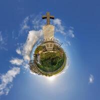 pequeño minúsculo planeta con tumba cruzar en cementerio en azul cielo con hermosa nubes transformación de esférico panorama 360 grados esférico resumen aéreo vista. curvatura de espacio. foto