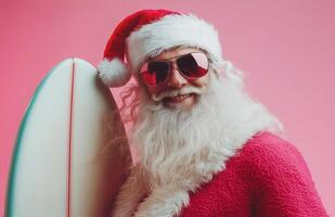 Santa Claus wearing sunglasses, holding a surfboard, smiling on a bright pink background photo
