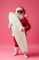 Santa Claus wearing sunglasses, holding a surfboard, smiling on a bright pink background photo