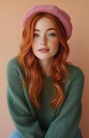 A cheerful young redhead in a green sweater and pink beret, smiling warmly photo