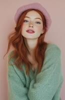 A cheerful young redhead in a green sweater and pink beret, smiling warmly photo