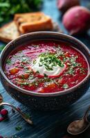 Borscht is a red beet soup with vegetables, served with sour cream in a bowl photo