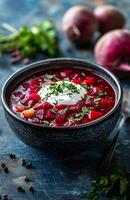 Borscht is a red beet soup with vegetables, served with sour cream in a bowl photo