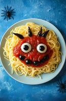 Spooky Halloween pasta with ketchup and a spider web set against a blue background photo