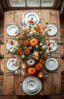 Autumn table setting featuring pumpkins, candles, and flowers on a wooden surface for festive decor photo