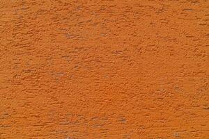 Orange plaster wall of a building. Rough surface texture. photo