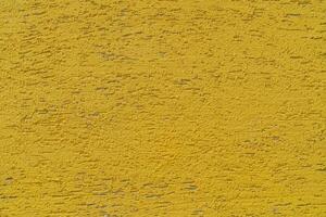 Yellow plaster wall of a building. Rough surface texture. photo